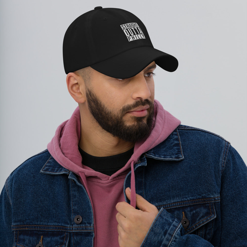 A 3/4 view of a man looking to the side while wearing a black baseball hat with "straight outta philly" embroidered on the front in white.