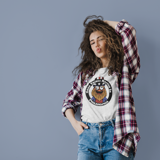 A photo of a woman posing whilst wearing a white graphic tee under a loose flannel.